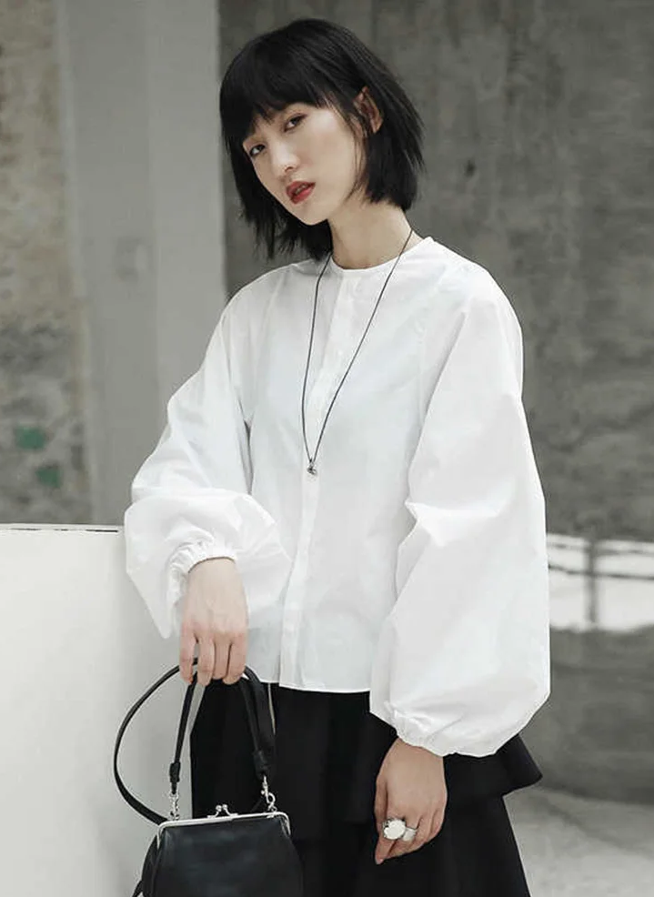 Woman wearing white Ai Enkei Loop Sleeve Shirt with dramatic balloon sleeves.