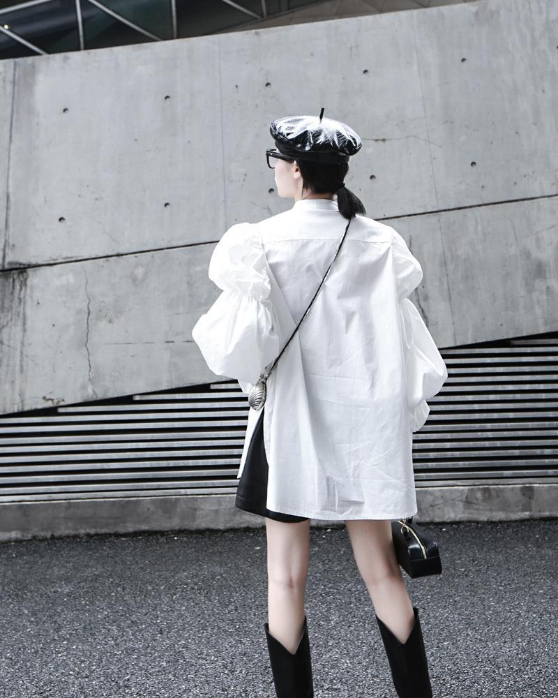 Woman wearing white Daoko Pleated Puff Long Sleeve Shirt with dramatic volume sleeves.