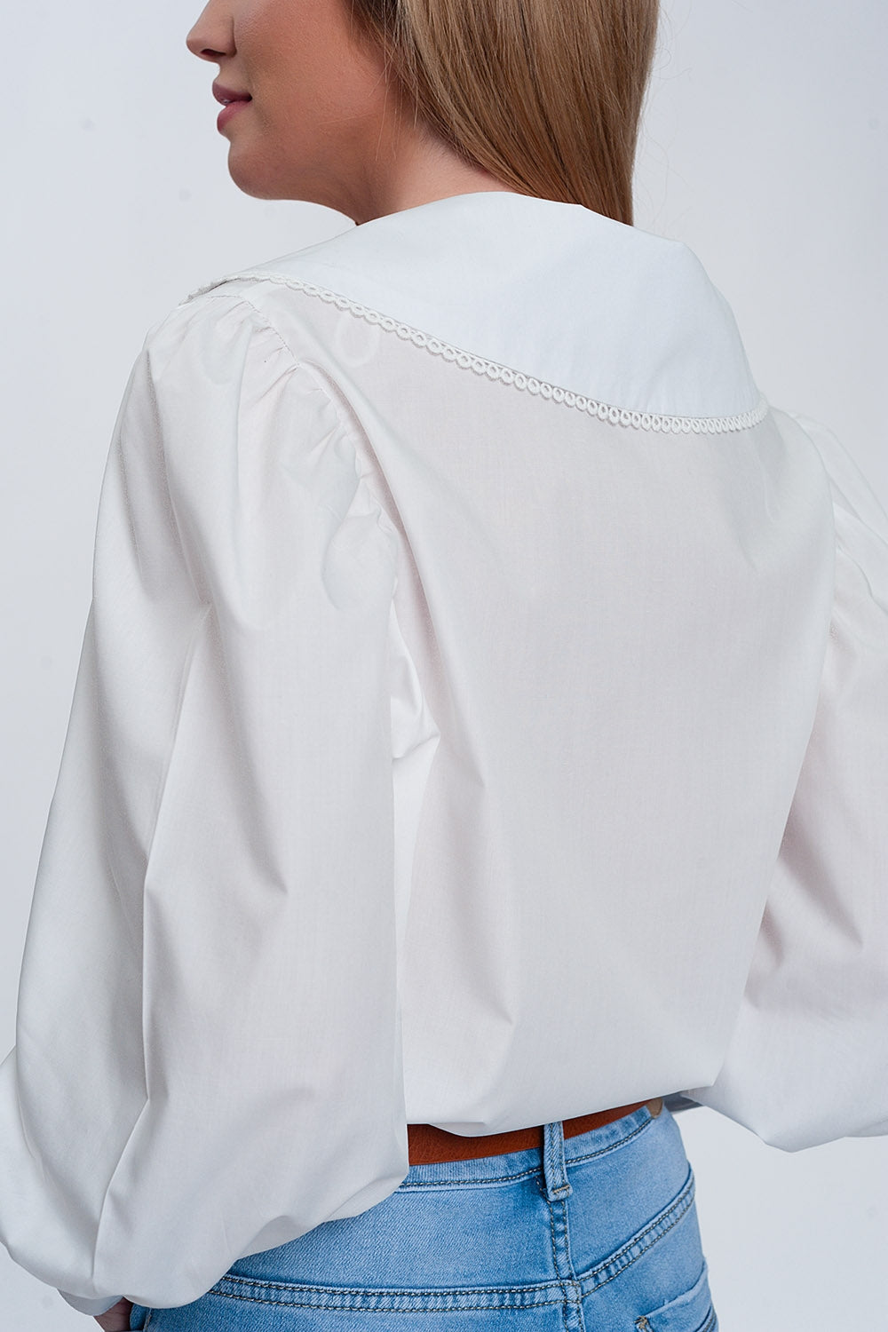 Woman wearing white oversized collared shirt with statement large collar