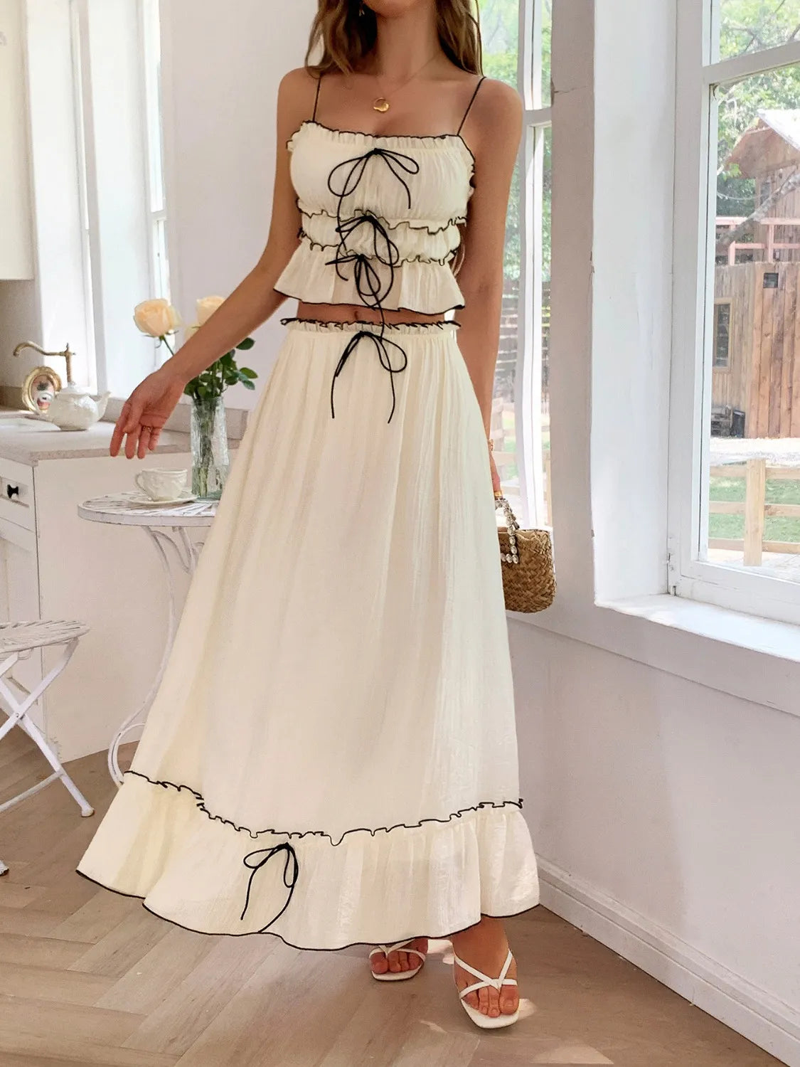 features a charming square neck cami with delicate frill detailing and matching maxi skirt.