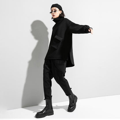 Woman wearing black oversized turtleneck pullover with utility pocket details.