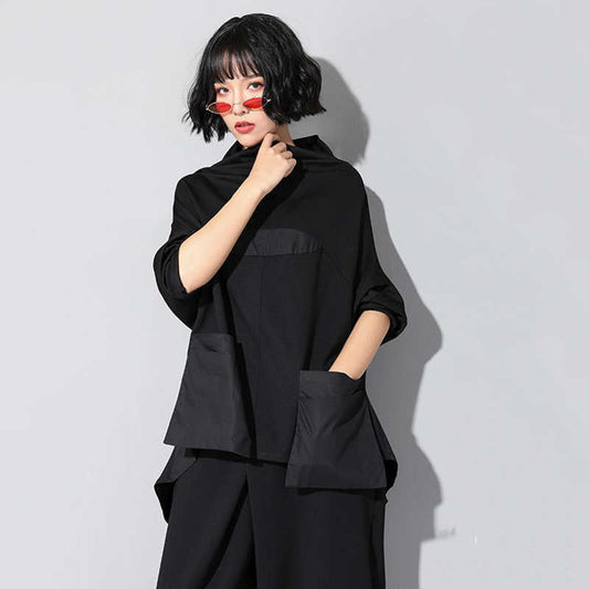 Woman wearing black Tenchi Big Pocket Shirt with distinctive large pockets.