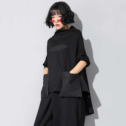 Woman wearing black Tenchi Big Pocket Shirt with distinctive large pockets.