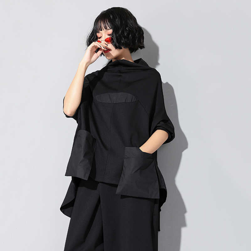 Woman wearing black Tenchi Big Pocket Shirt with distinctive large pockets.
