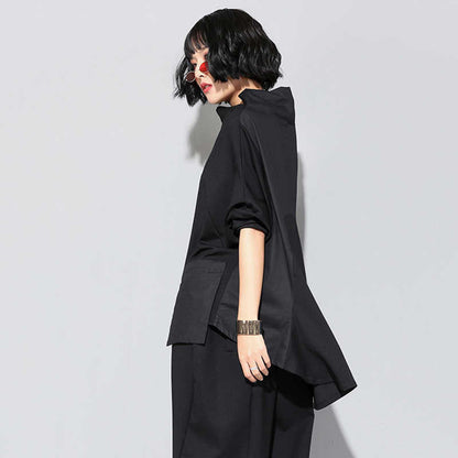 Woman wearing black Tenchi Big Pocket Shirt with distinctive large pockets.