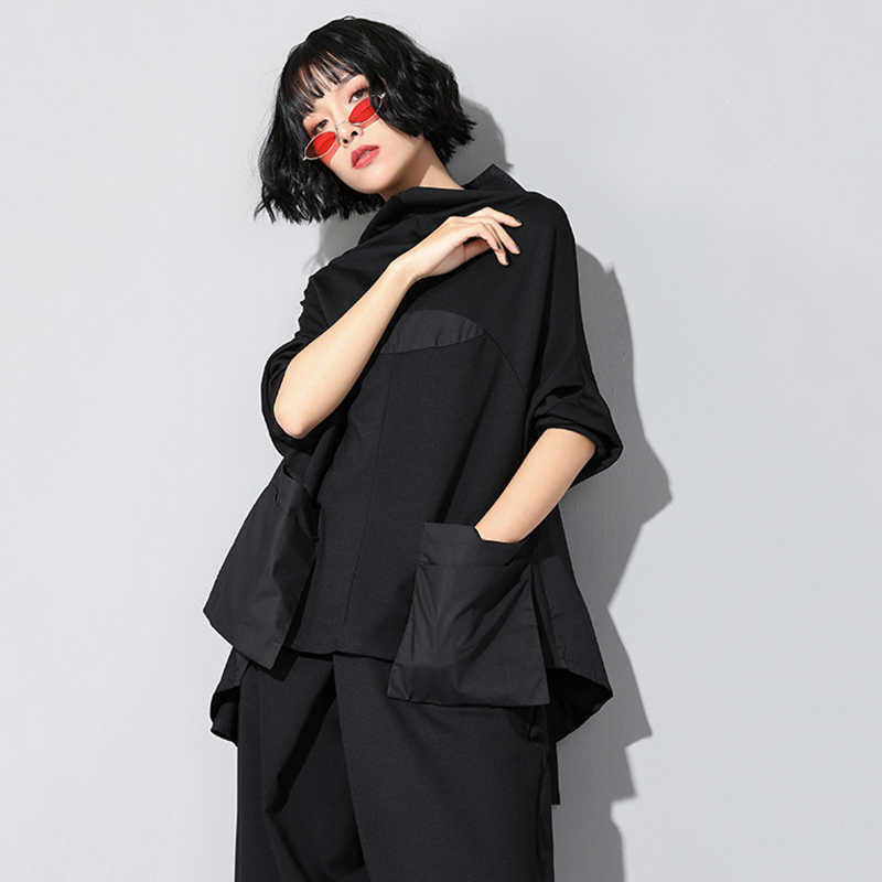 Woman wearing black Tenchi Big Pocket Shirt with distinctive large pockets.