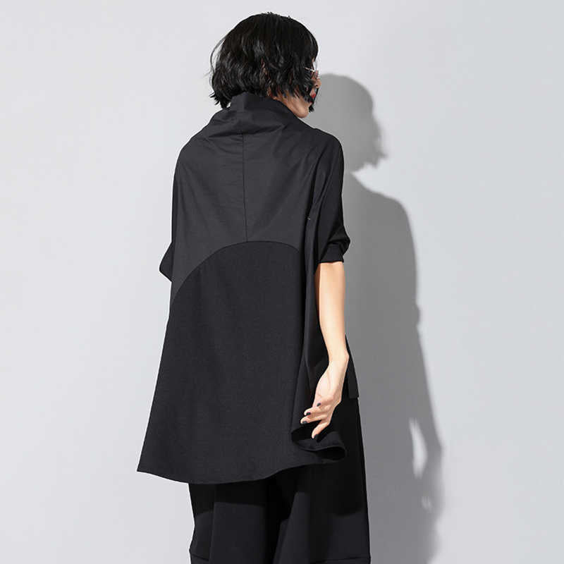 Woman wearing black Tenchi Big Pocket Shirt with distinctive large pockets.
