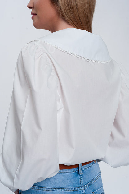 Woman wearing white oversized collared shirt with statement large collar